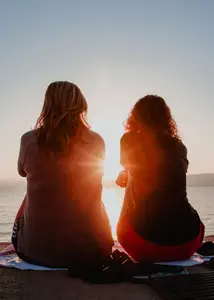 two friends watching the sunrise over the mountains