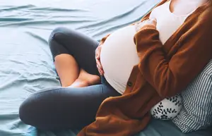 pregnant woman cradling her baby bump