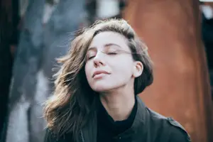 calm woman eyes closed wind in her hair