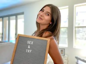 fertility blogger erin bulcao with a sign that reads "Sex & IVF"