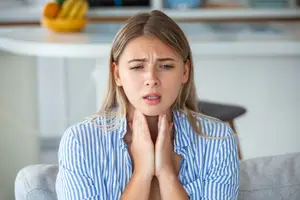 woman examining her thyroid