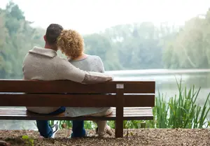 couple on a bench staring at a lake