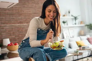 woman eating a salad in the kitchen