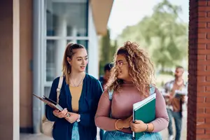 two female college students walking on campus