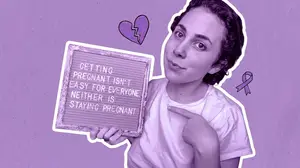infertility warrior arden cartrette holding a sign that reads "getting pregnant is easy for everyone, neither is staying pregnant"